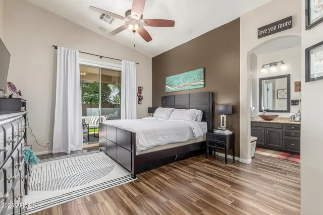 a bedroom with a bed table closet and flat screen tv