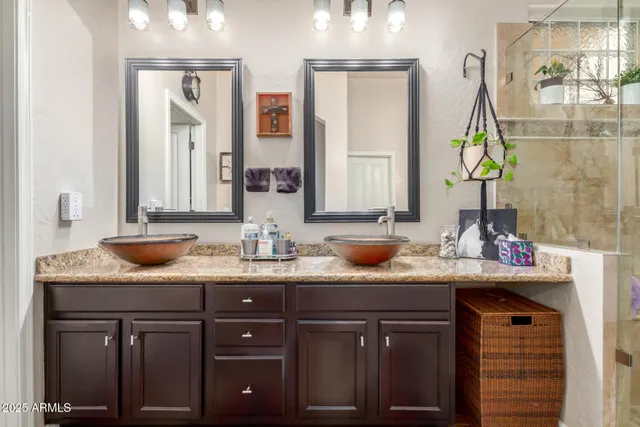 a bathroom with a granite countertop shower a sink and vanity
