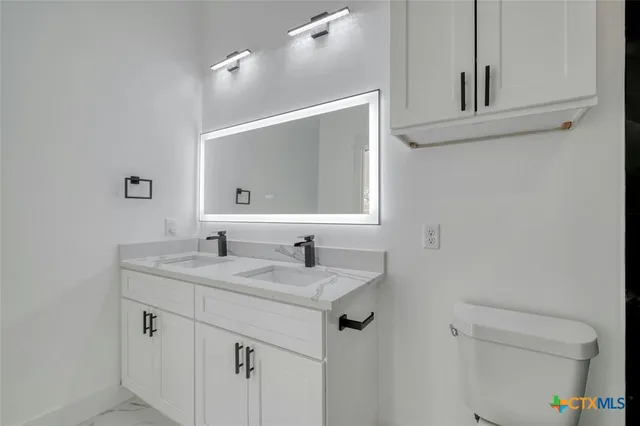 a bathroom with a sink toilet a mirror and shower