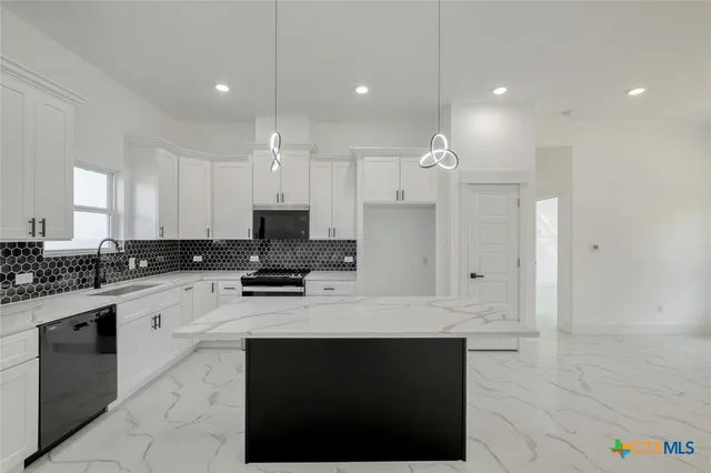 a kitchen with a sink cabinets and stainless steel appliances