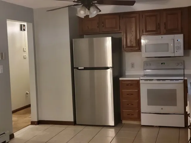 a kitchen with stainless steel appliances granite countertop a refrigerator and a stove top oven