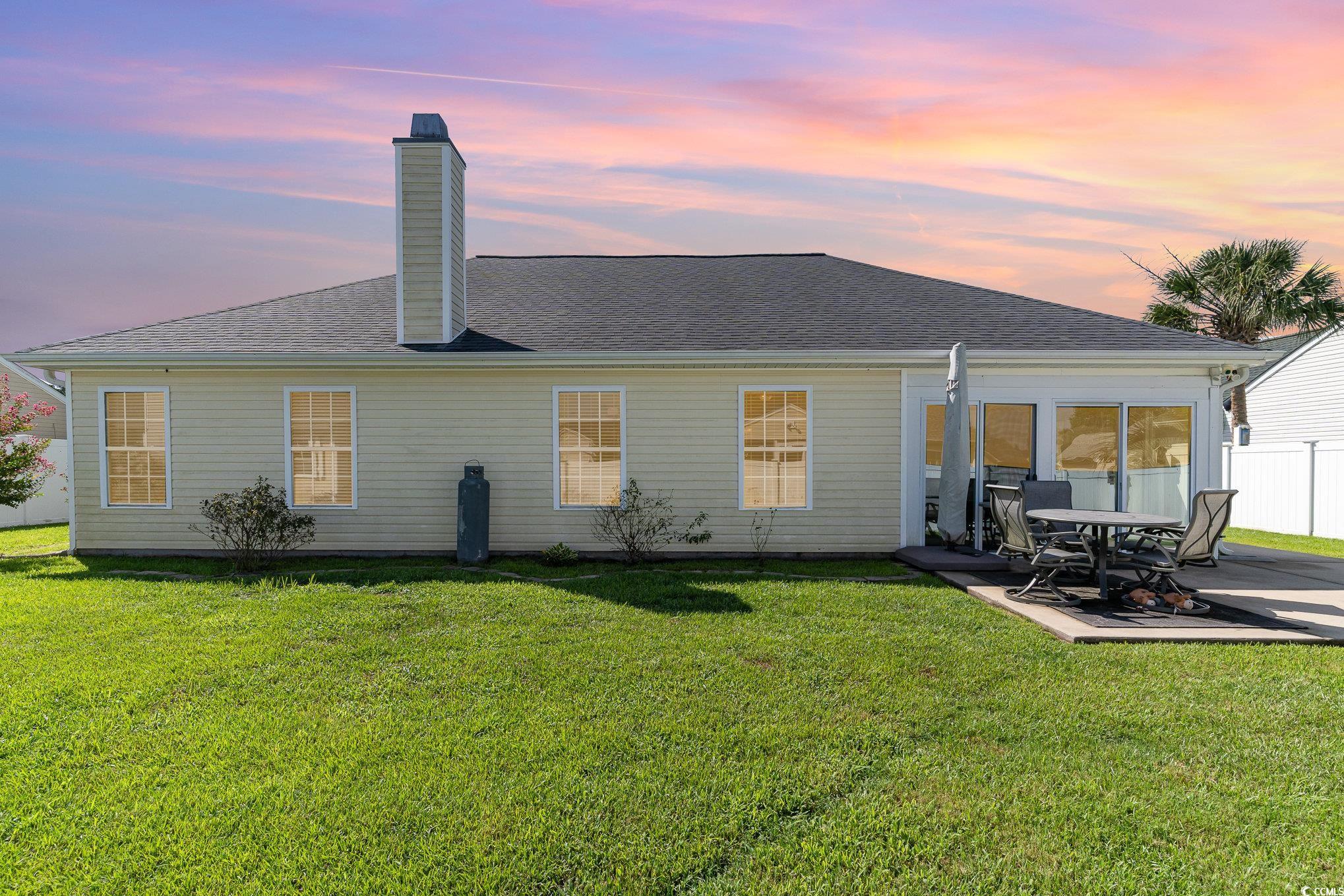 625 Seth Lane Longs, SC 29568 - Photo 26 of 34 Back house at dusk featuring a patio and a yard