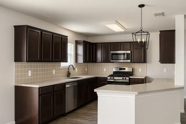 a kitchen with stainless steel appliances a sink stove and microwave