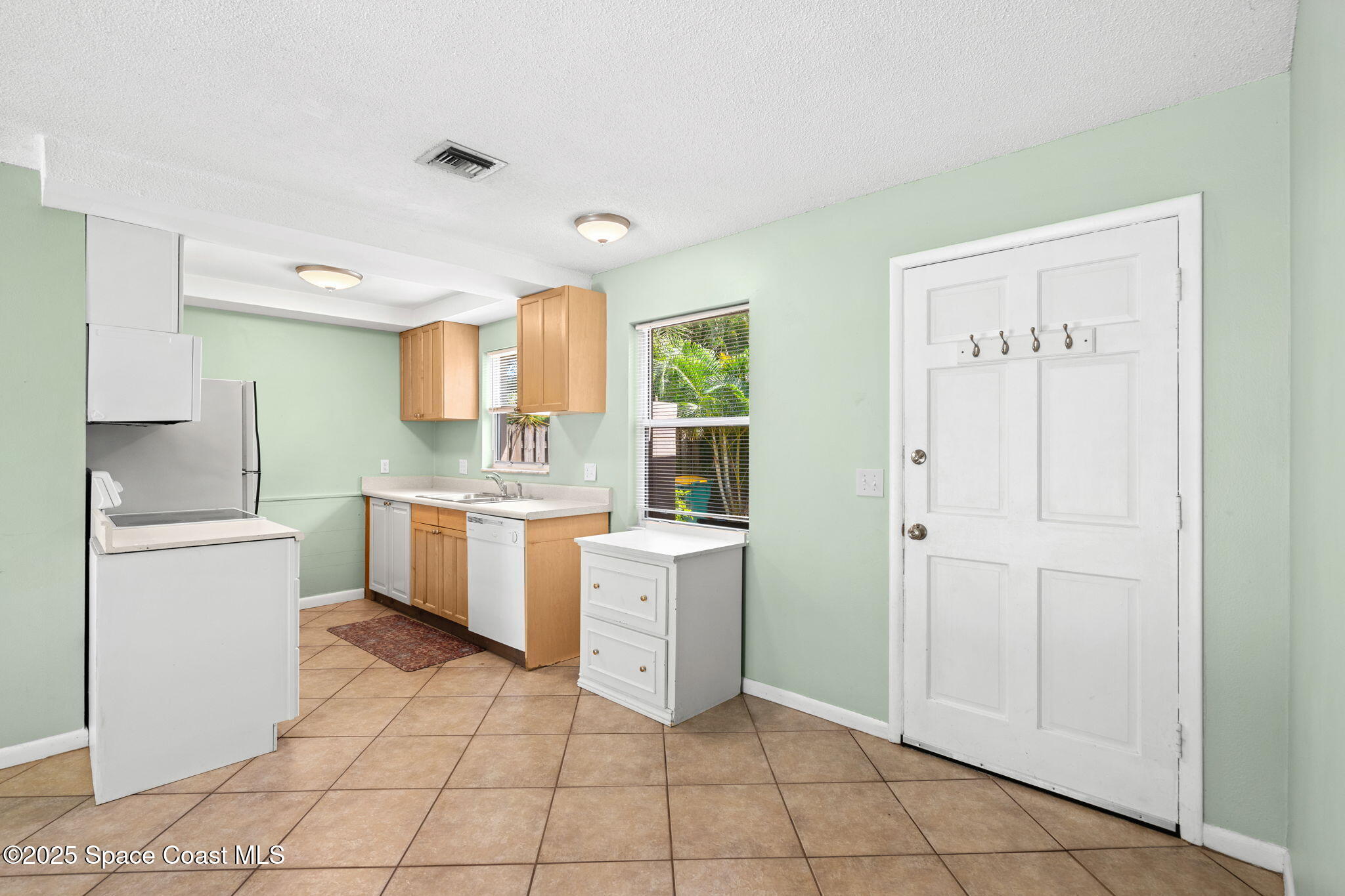 2902 Emory Street Melbourne, FL 32901 - Photo 32 of 46 a kitchen with a refrigerator and white cabinets