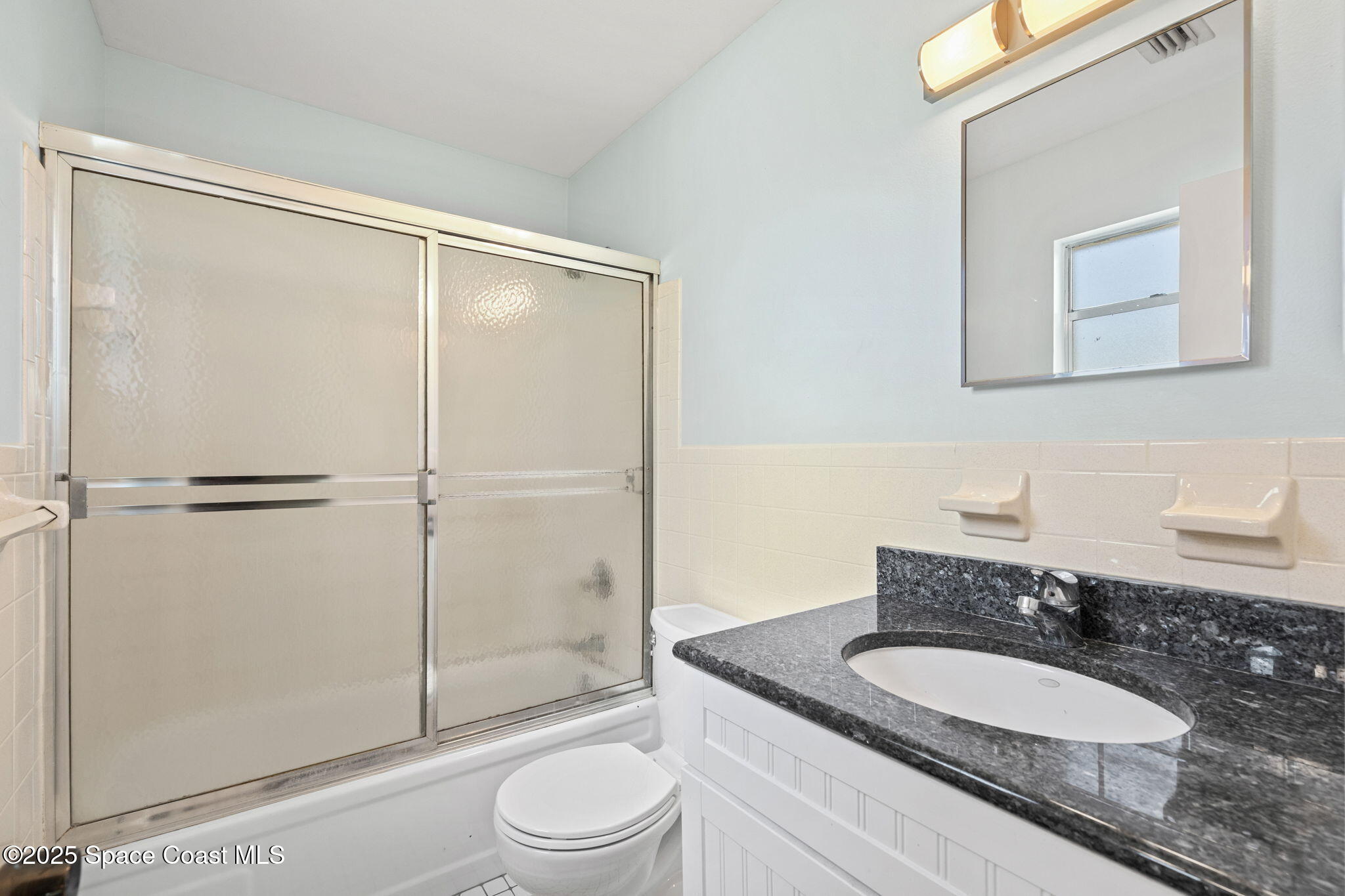 2902 Emory Street Melbourne, FL 32901 - Photo 38 of 46 a bathroom with a granite countertop sink toilet a mirror and shower