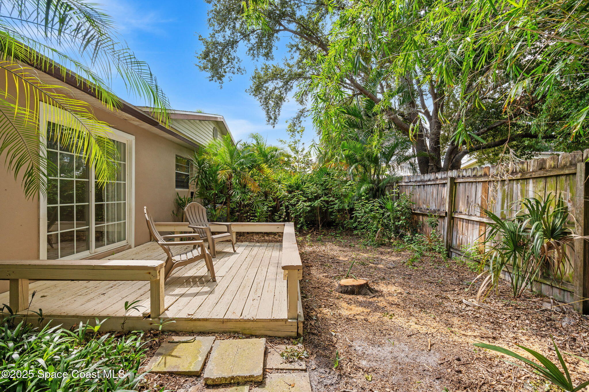 2902 Emory Street Melbourne, FL 32901 - Photo 42 of 46 a view of a patio with table and chairs and potted plants with wooden fence