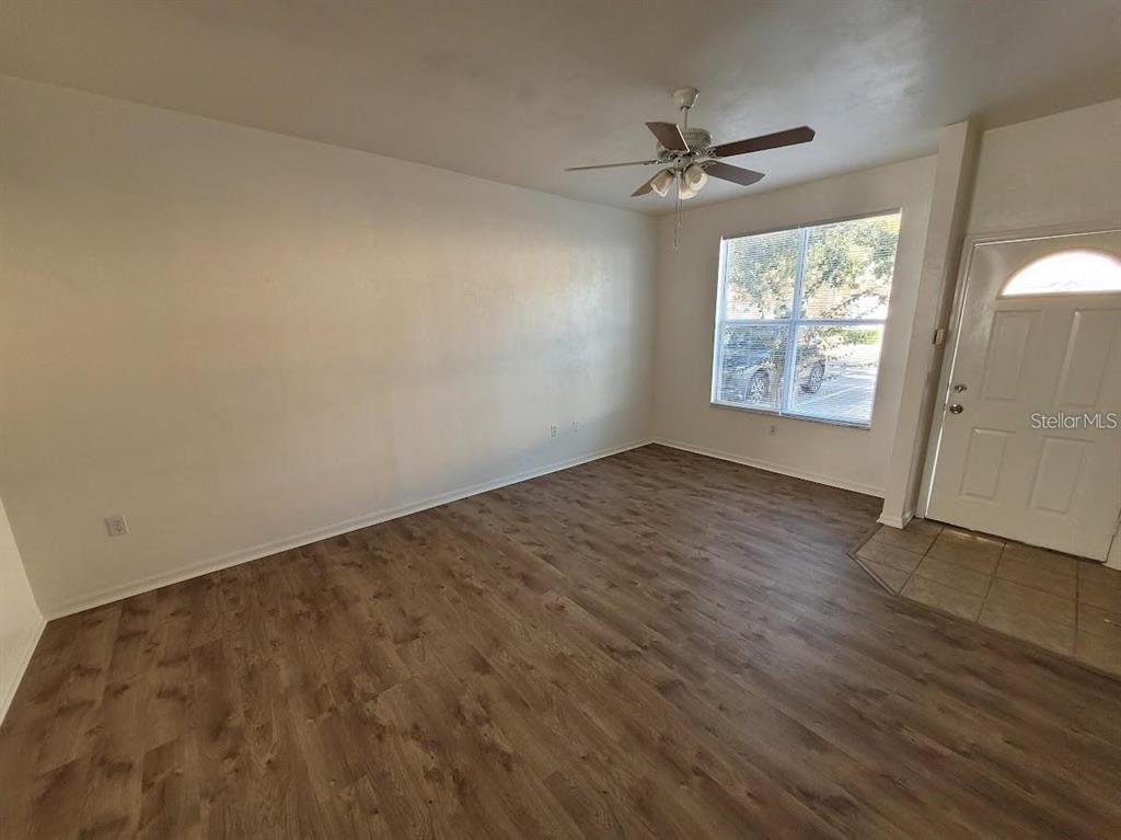 3890 Southwest 20th Avenue, Unit 1712 Gainesville, FL 32607 - Photo 5 of 19 an empty room with windows ceiling fan and hardwood floor