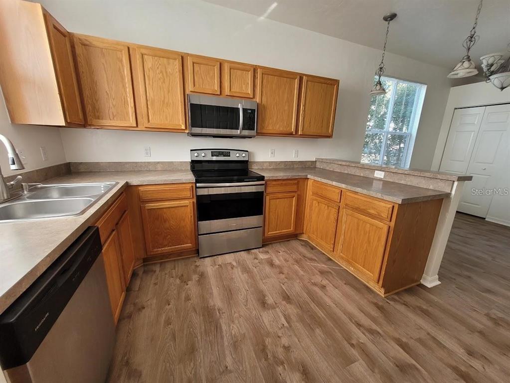 3890 Southwest 20th Avenue, Unit 1712 Gainesville, FL 32607 - Photo 7 of 19 a kitchen with stainless steel appliances granite countertop a sink stove and microwave