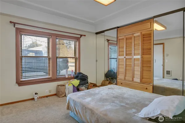a spacious bedroom with a bed and glass windows