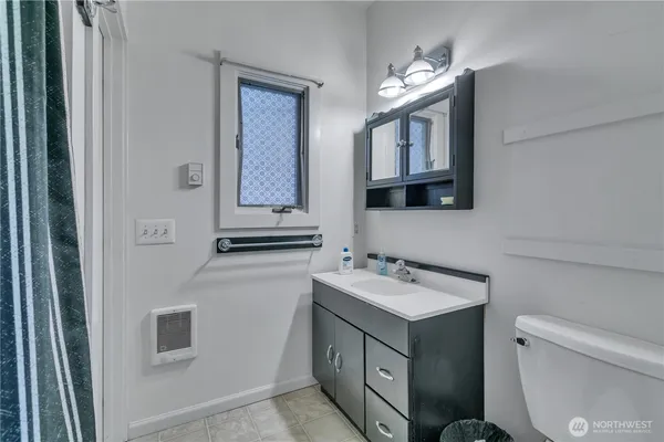 a bathroom with a toilet sink and mirror