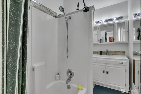 a bathroom with a bathtub a sink a vanity and mirrors