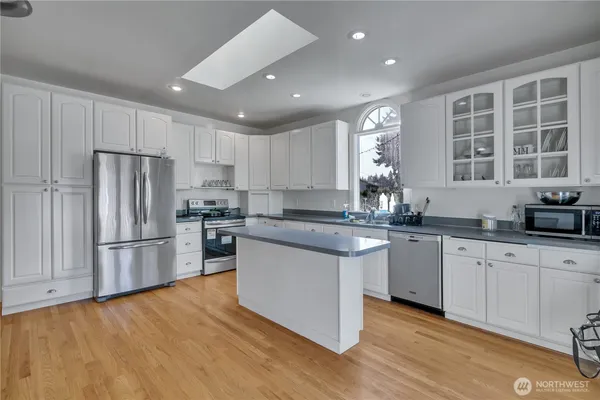 a kitchen with stainless steel appliances granite countertop a refrigerator and a stove top oven