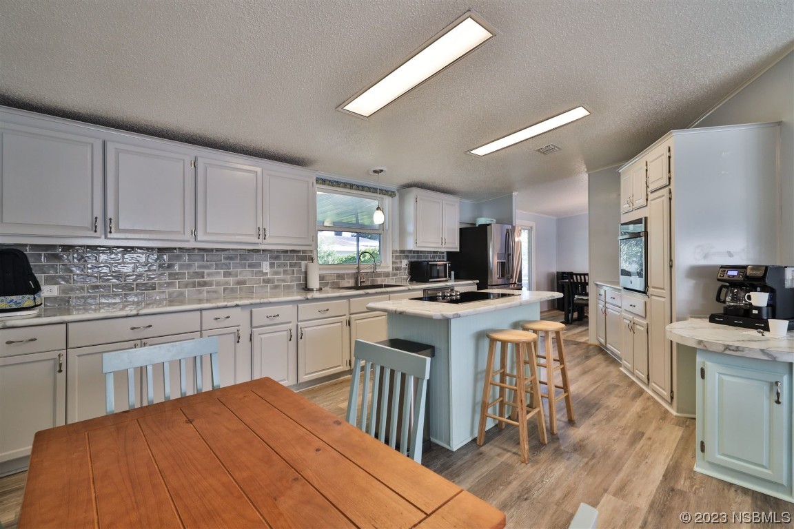 502 Topside Circle Edgewater, FL 32141 - Photo 12 of 28 a kitchen with stainless steel appliances kitchen island granite countertop a stove top oven a sink a dining table and chairs