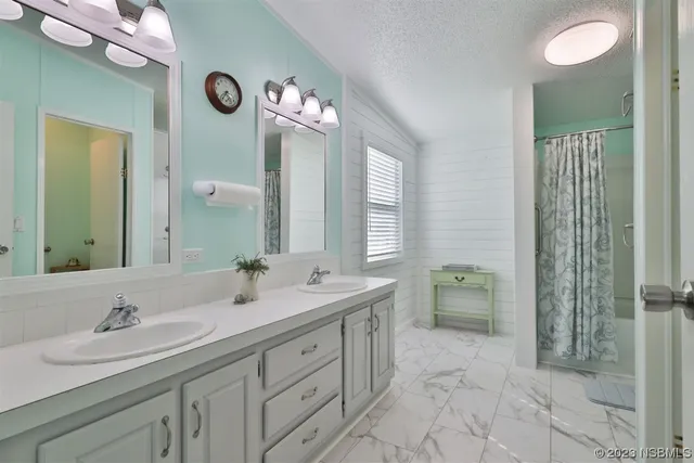 a bathroom with double sink and a mirror