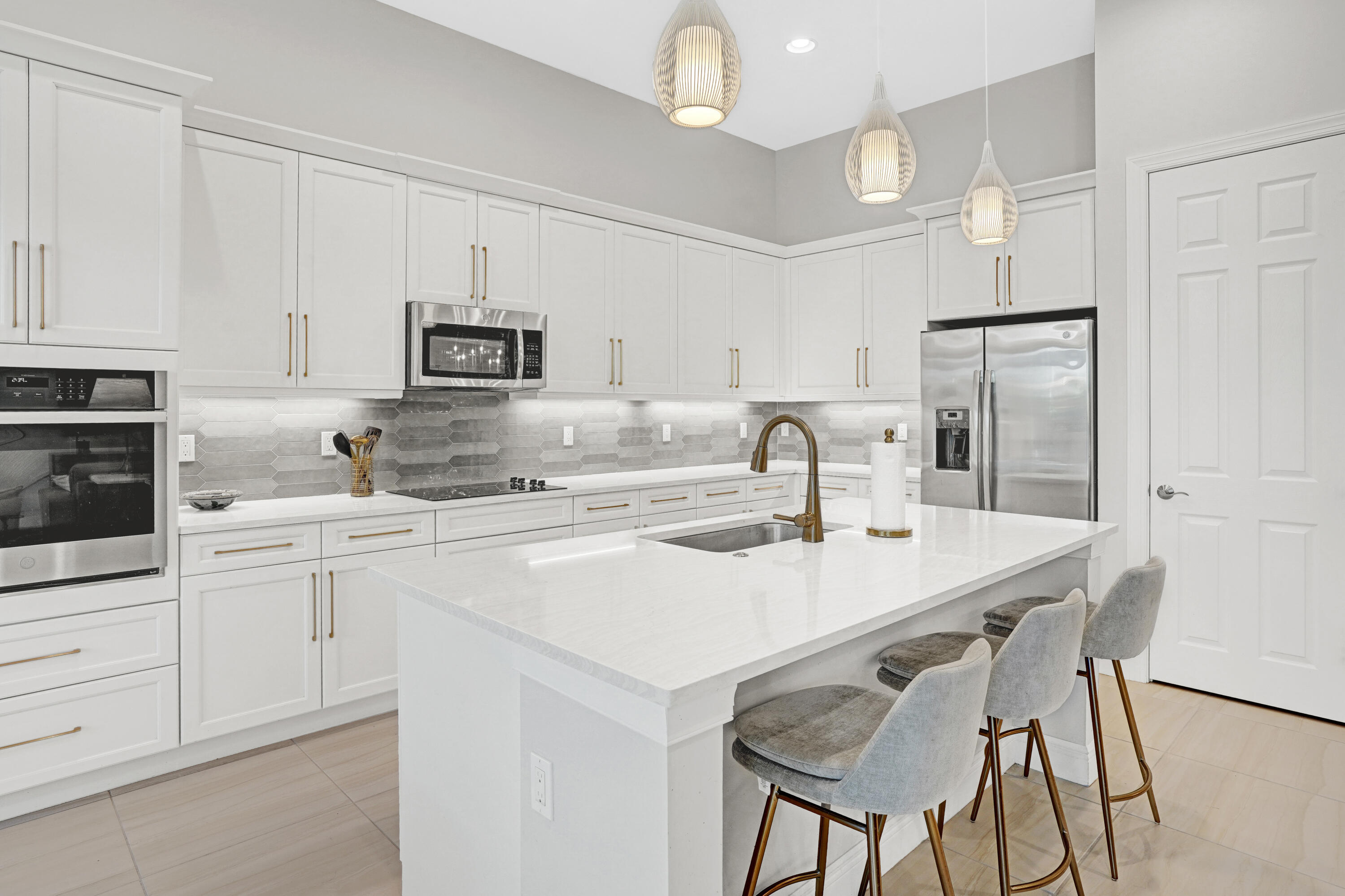23005 Southwest Accesi Way Port St. Lucie, FL 34986 - Photo 23 of 80 a kitchen with stainless steel appliances granite countertop a sink a stove a refrigerator and white cabinets with wooden floor