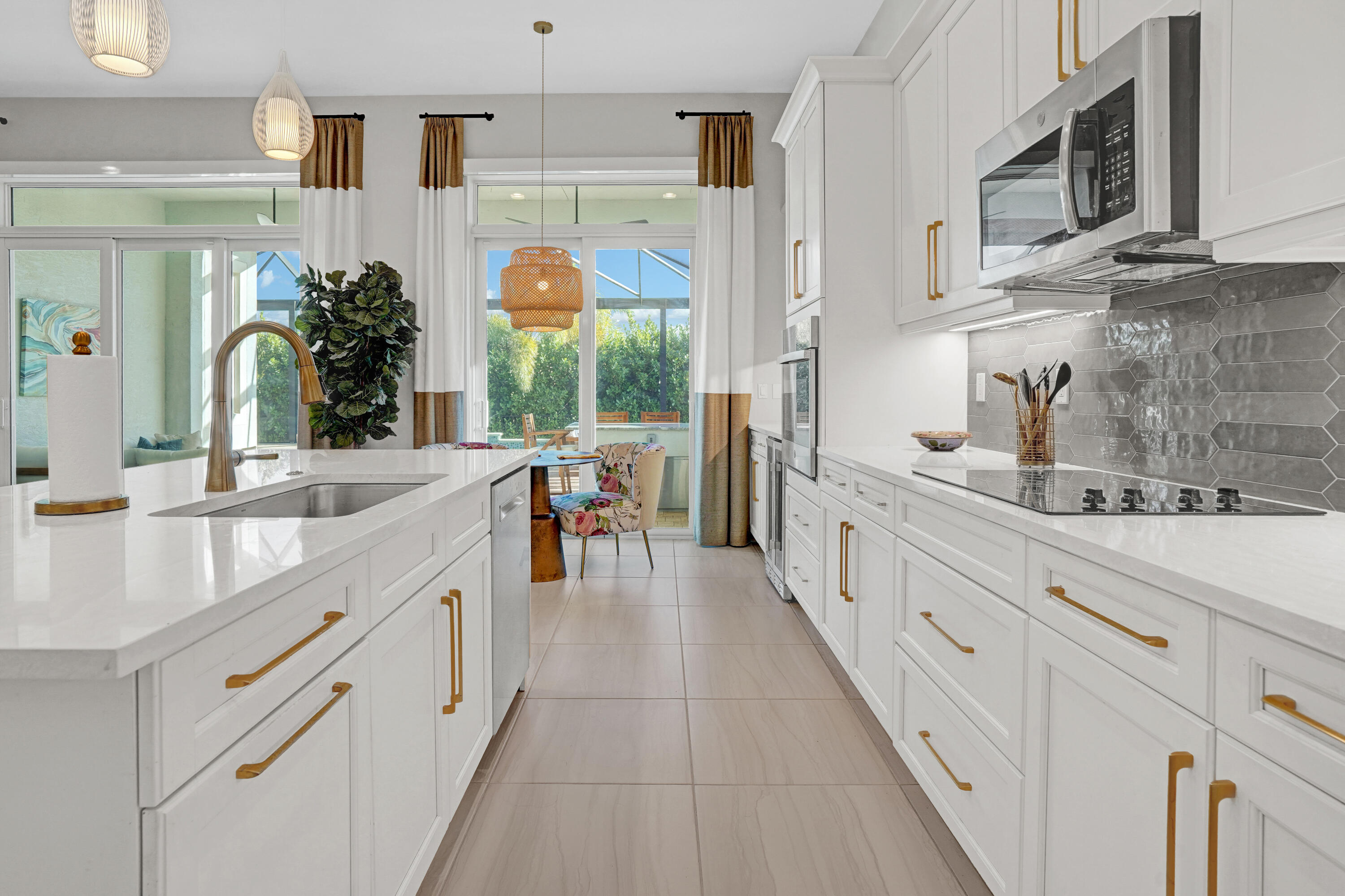 23005 Southwest Accesi Way Port St. Lucie, FL 34986 - Photo 24 of 80 a large white kitchen with granite countertop a sink and dishwasher a stove top oven with wooden floor