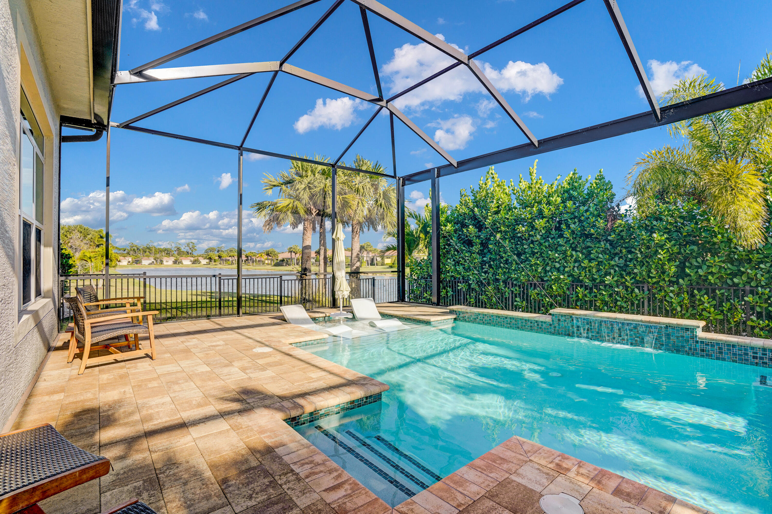 23005 Southwest Accesi Way Port St. Lucie, FL 34986 - Photo 42 of 80 a view of a patio with a table and chairs under an umbrella