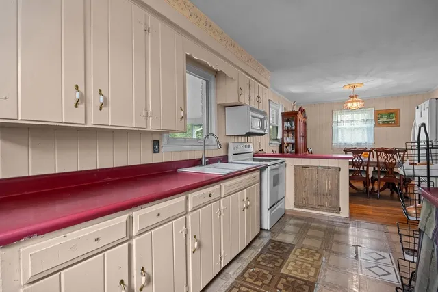 a kitchen with sink cabinets and stove top oven