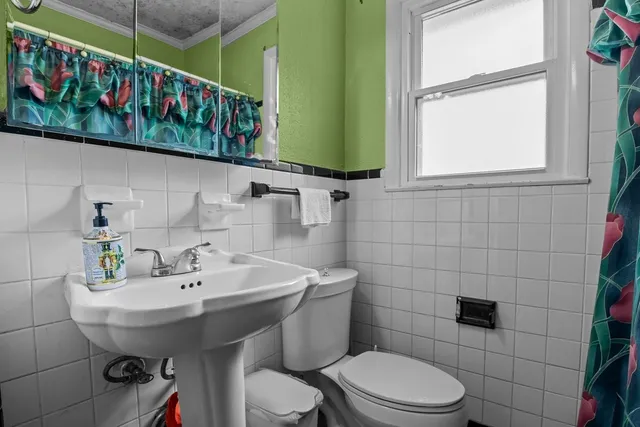 a bathroom with a sink a toilet and mirror