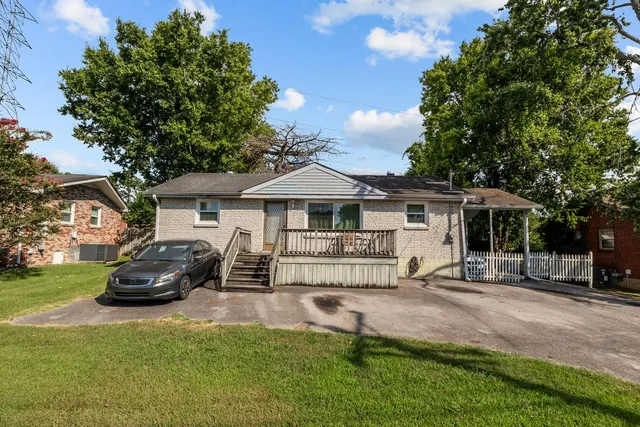 a front view of a house with a garden and trees