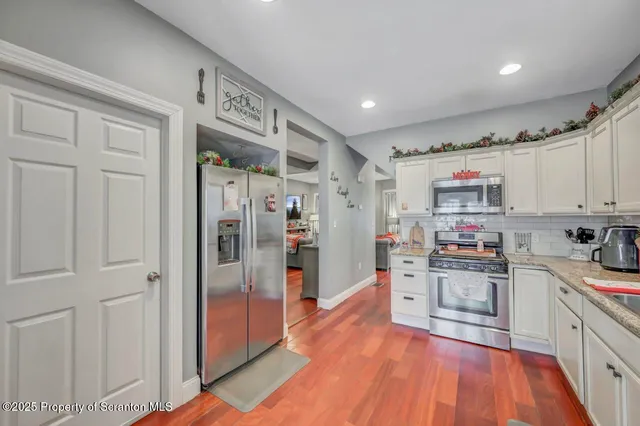 a kitchen with stainless steel appliances granite countertop a refrigerator and a stove top oven