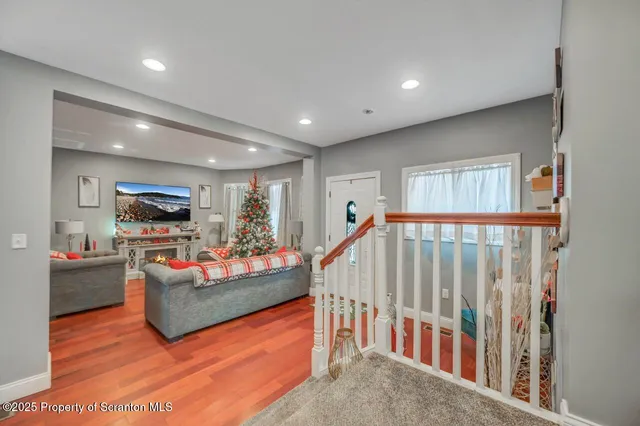 a view of staircase with wooden floor and white walls