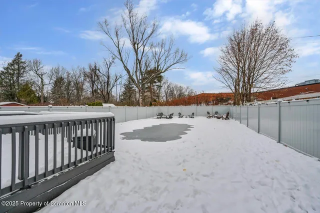 a view of swimming pool with seating area and trees in the background