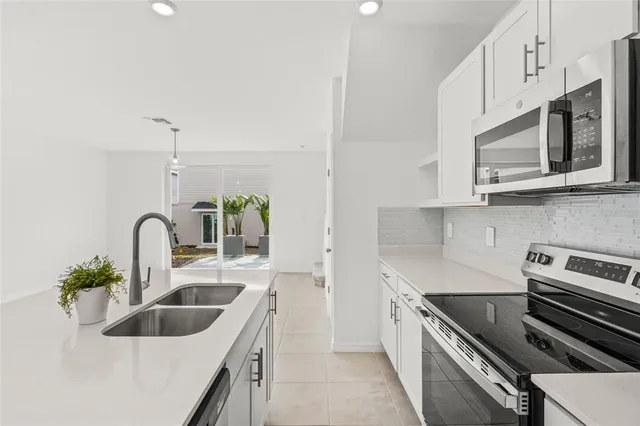 a kitchen with stainless steel appliances granite countertop a sink a stove and cabinets