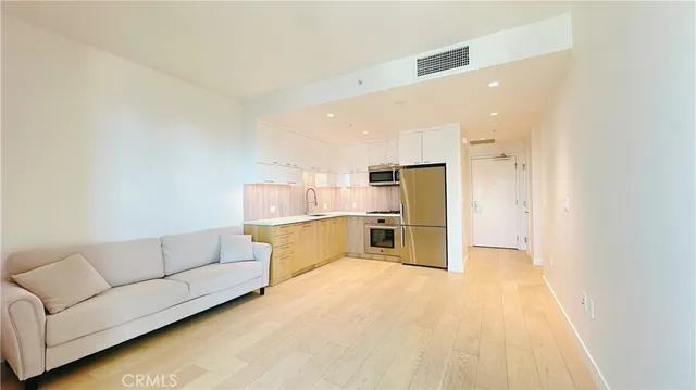 a living room with stainless steel appliances kitchen island furniture and a kitchen view