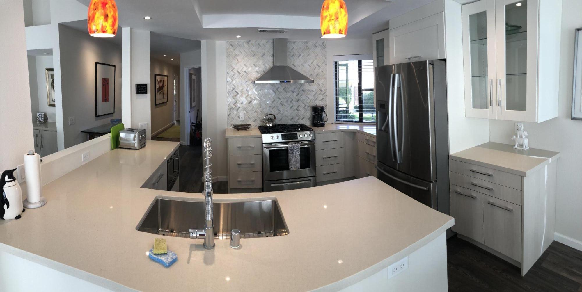 a kitchen with a sink stainless steel appliances a refrigerator and cabinets