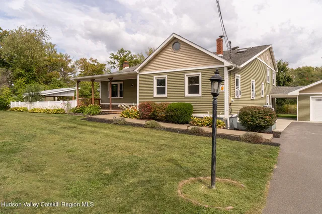 a front view of house with yard and trees in the background