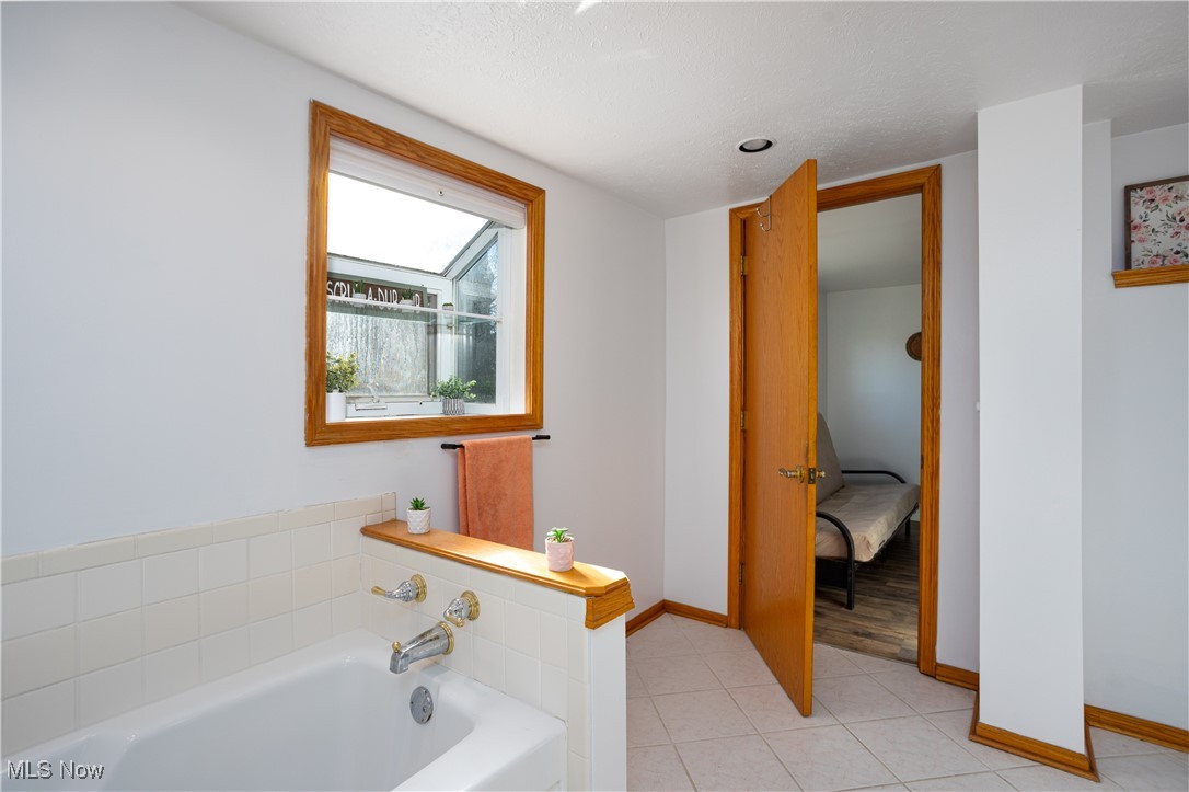 1848 Wright Road Akron, OH 44320 - Photo 23 of 32 Bathroom with a washtub, a textured ceiling, and tile patterned floors