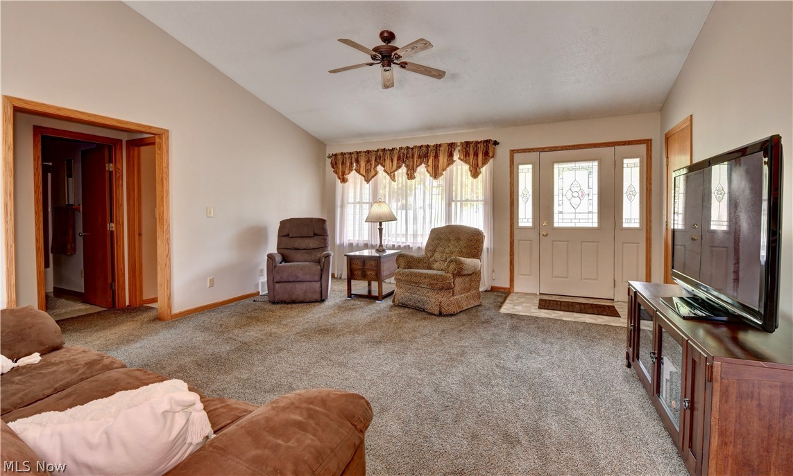 3318 Simpson Road Southeast Dennison, OH 44621 - Photo 10 of 31 Carpeted living room with vaulted ceiling and ceiling fan