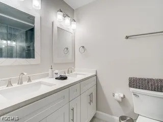 a bathroom with a sink a toilet and a mirror