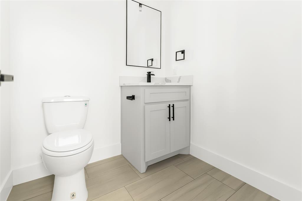 1101 Poindexter Street, Unit A2 Fort Worth, TX 76102 - Photo 11 of 40 a bathroom with a toilet sink and mirror