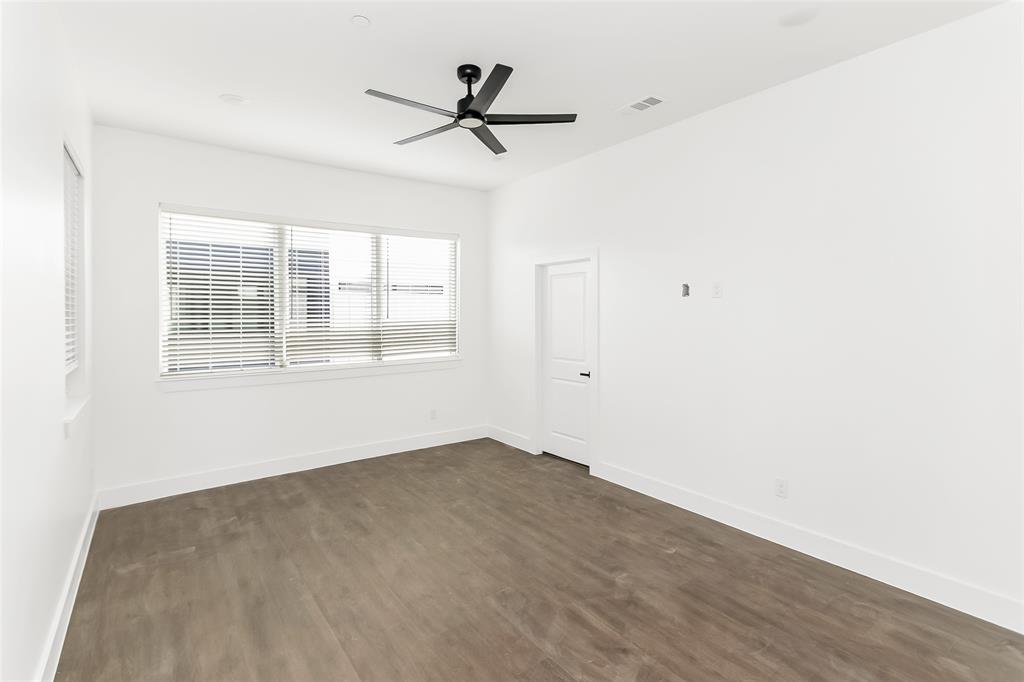 1101 Poindexter Street, Unit A2 Fort Worth, TX 76102 - Photo 14 of 40 an empty room with wooden floor fan and windows