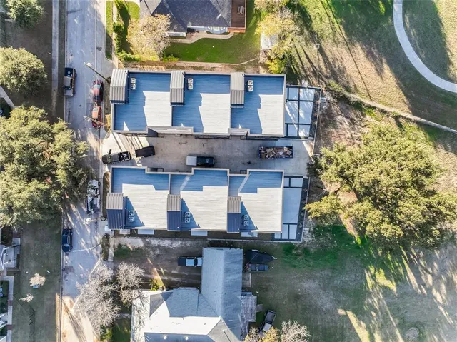 a aerial view of a house with swimming pool and large trees
