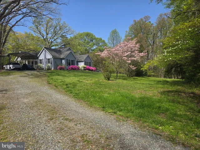 a view of a big house with a big yard and large trees