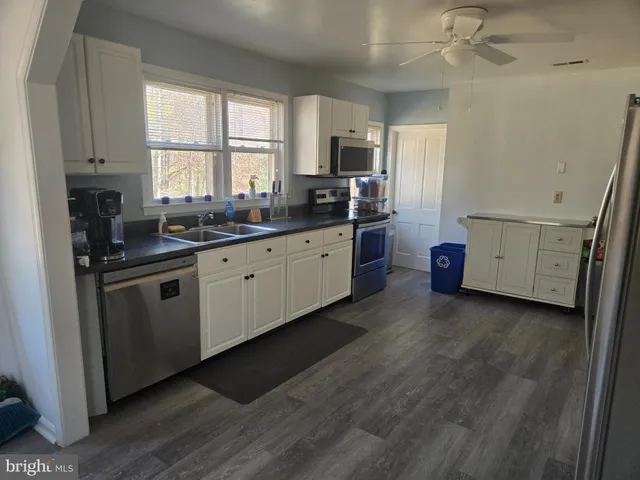 a kitchen with sink a microwave and cabinets