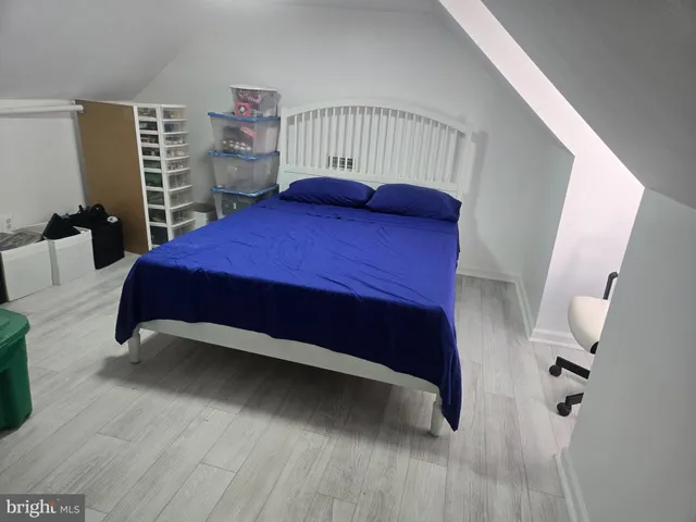 a bedroom with a bed and a wooden floor