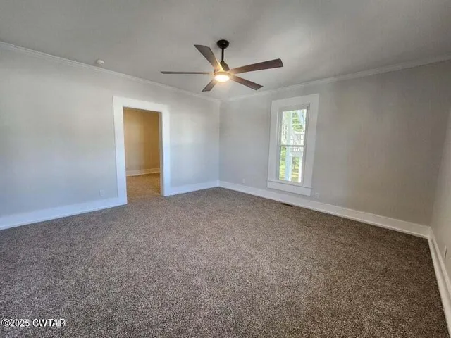 a view of empty room with ceiling fan