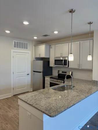 a kitchen with kitchen island a counter top space appliances and cabinets