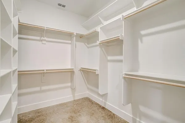 a view of walk in closet with empty racks