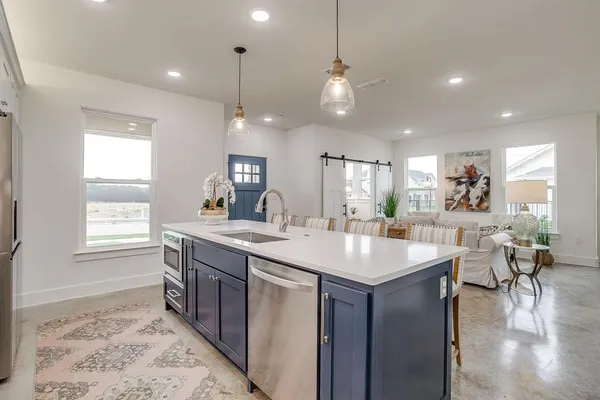 a kitchen with counter top space a sink appliances and living room
