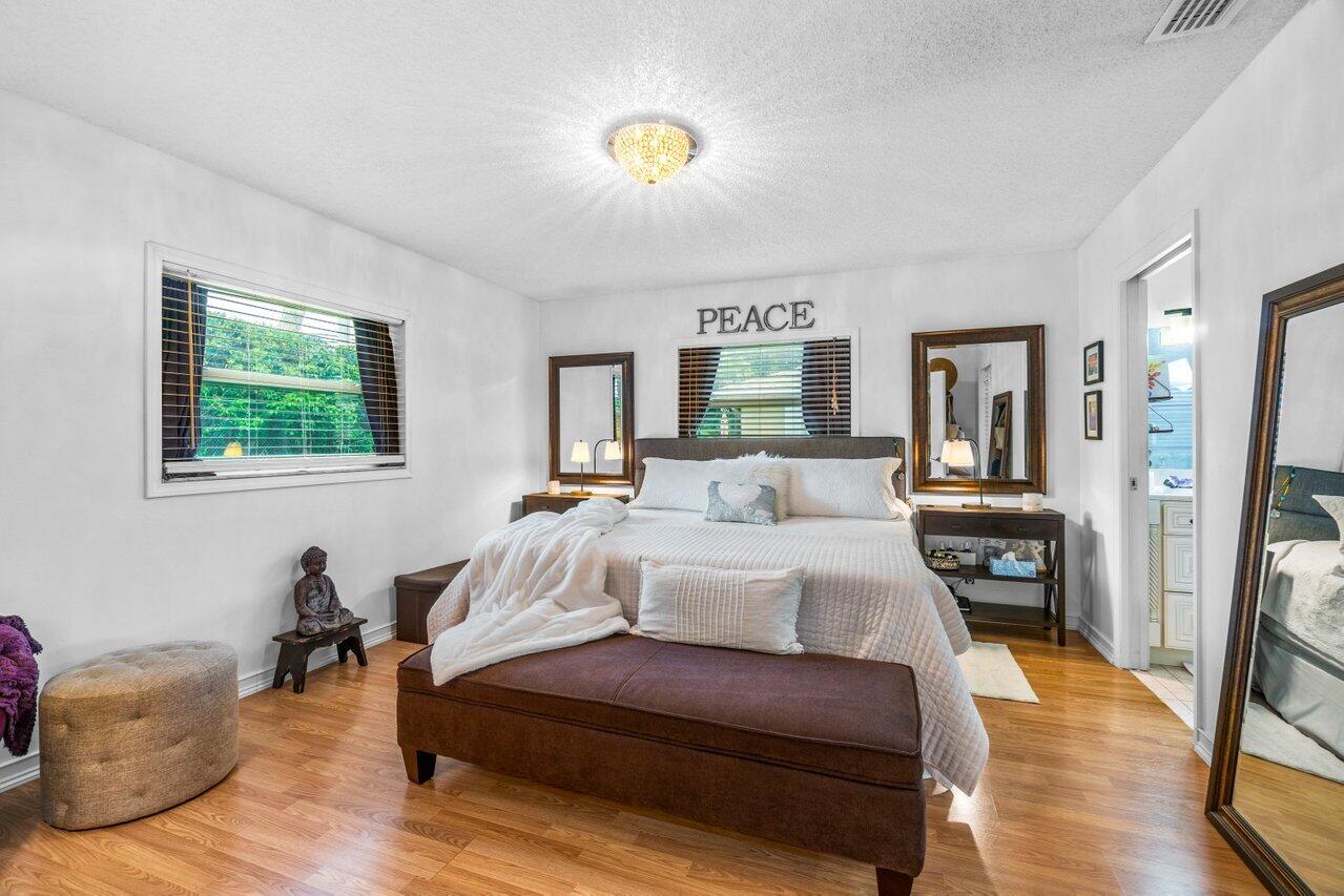 18855 Candlewick Drive Boca Raton, FL 33496 - Photo 18 of 27 a spacious bedroom with a bed and a chandelier