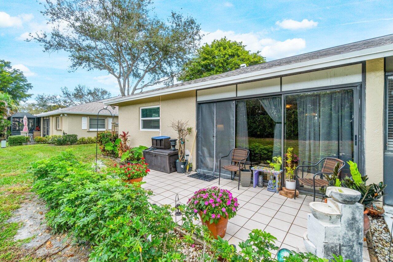 18855 Candlewick Drive Boca Raton, FL 33496 - Photo 25 of 27 a view of a house with backyard sitting area and garden