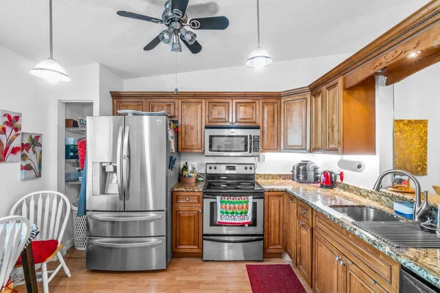 a kitchen with stainless steel appliances a refrigerator sink and cabinets