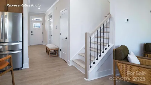 a view of a hallway with wooden floor and staircase