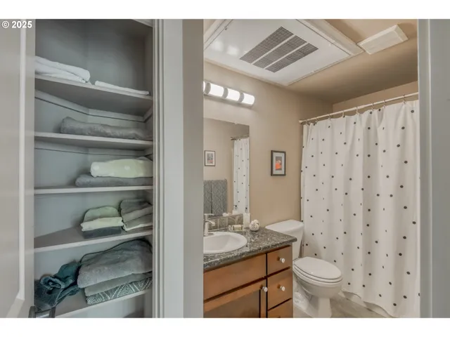 a bathroom with a granite countertop sink a toilet and a shower