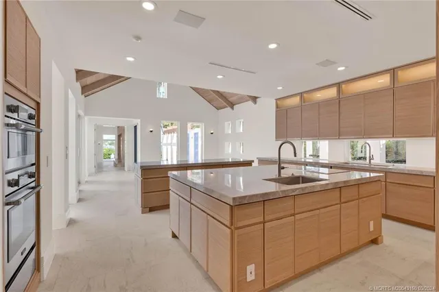 a kitchen with granite countertop a sink and white cabinets